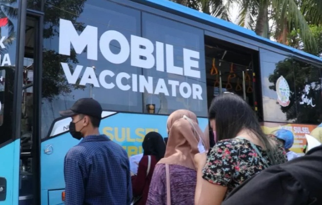 Masyarakat mengantre untuk menjalani vaksinasi di layanan mobil vaksinasi keliling di Makassar