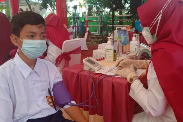 Pelaksanaan vaksinasi COVID-19 secara massal bagi siswa SMP di Kota Makassar, Sulawesi Selatan.